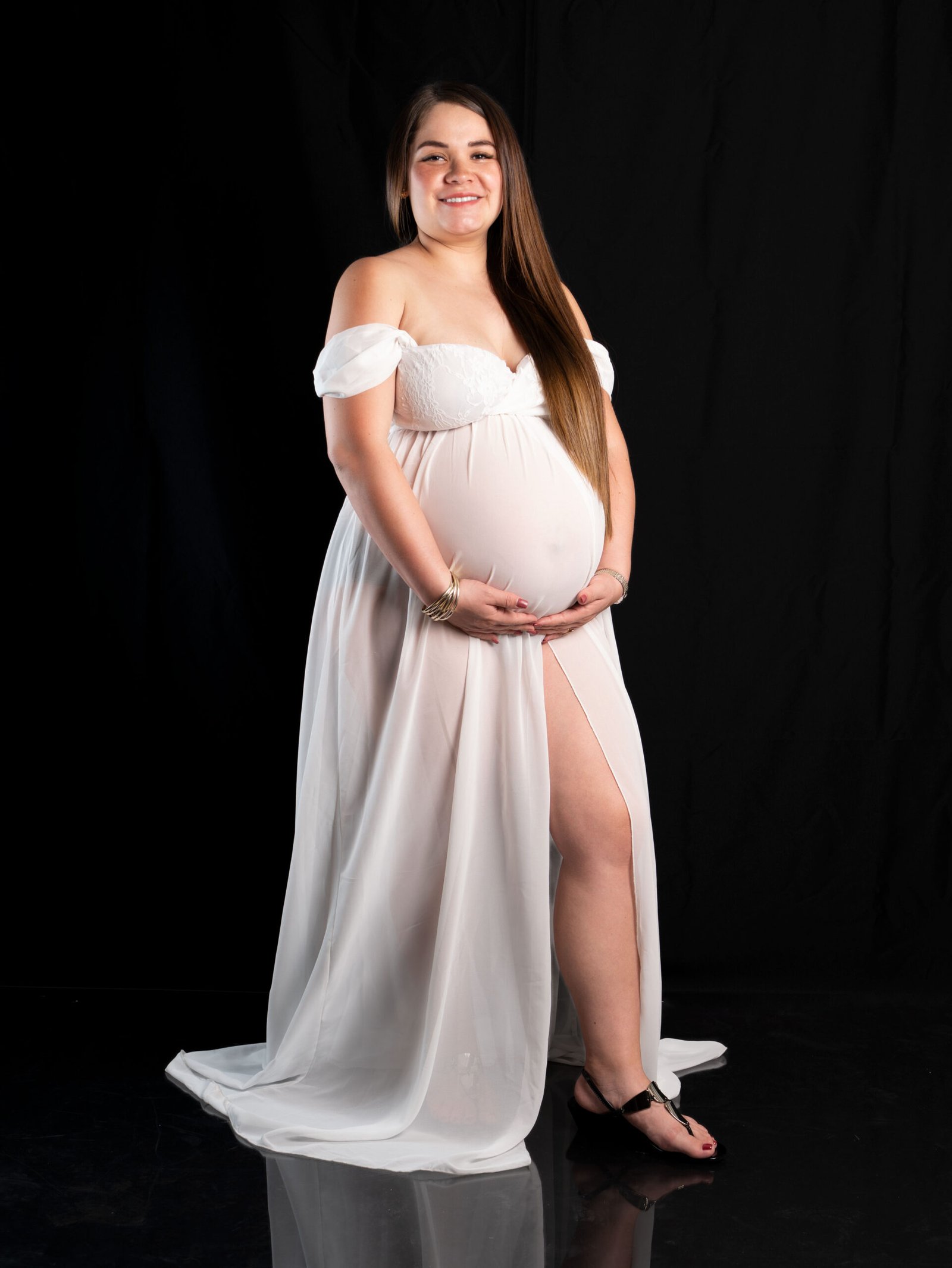Madre gestante con vestido blanco en sesión fotográfica de embarazo